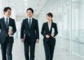 男性2人と女性1人がオフィスで歩いている画像