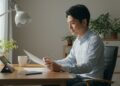 書類を読む日本人男性と明るい室内の画像