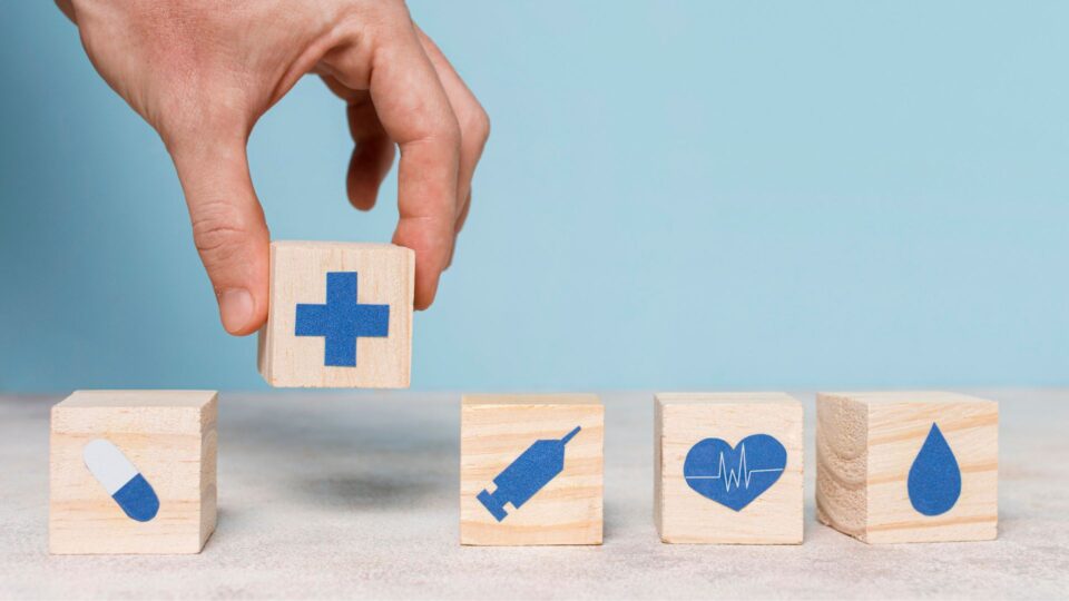 医療や健康を示すアイコン入りブロックを並べる手