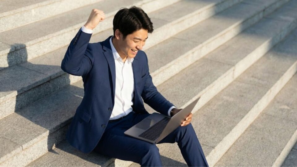 ガッツポーズをするスーツ姿のビジネスパーソン
