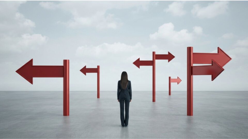 複数の方向を示す矢印の前で立ち止まる人物
